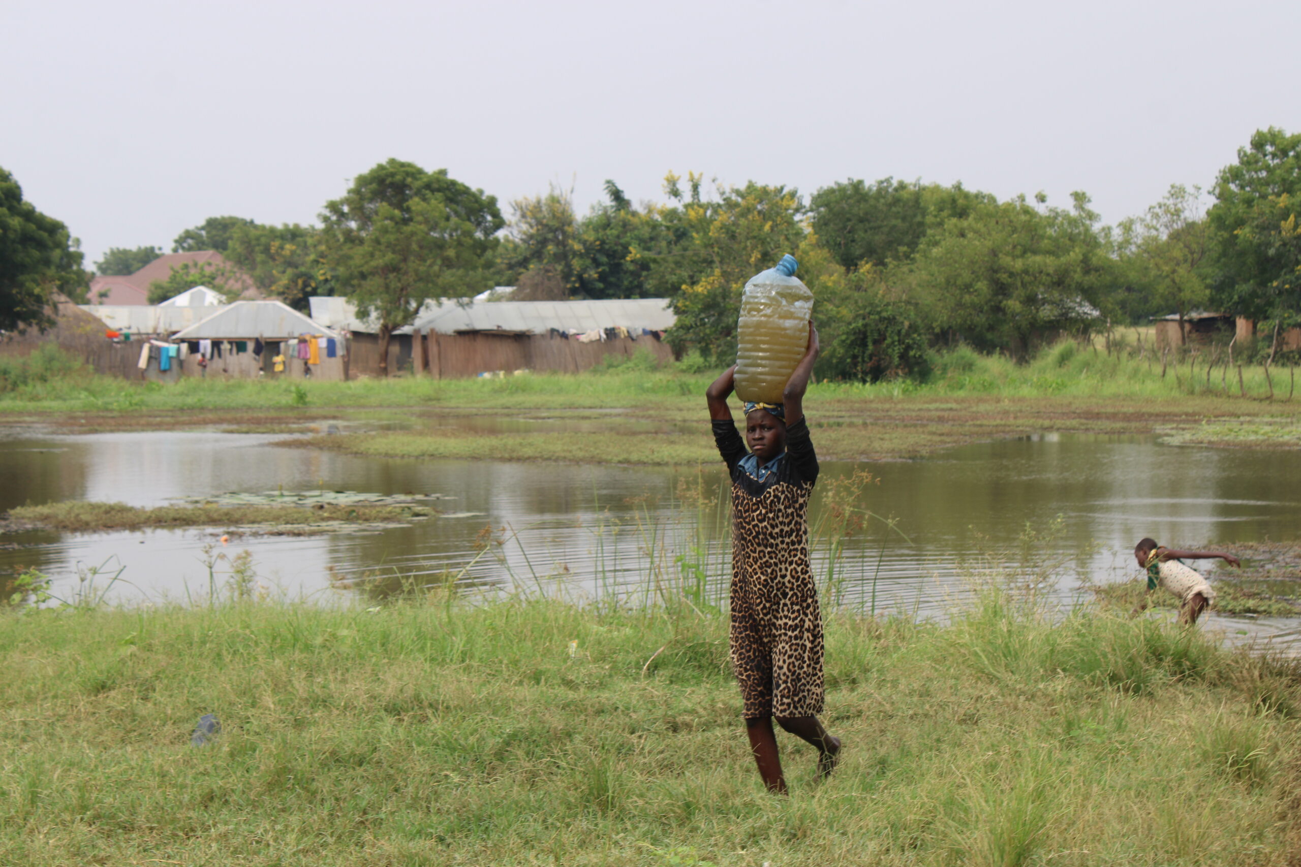 Girls fetching water from a floodwaters in Buliisa district along Lake Albert shores in Western Uganda. Credit: Robert Atuhairwe/The Albertine Journal