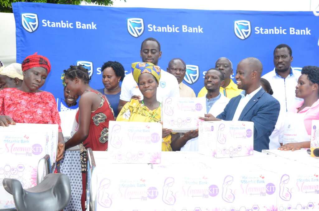 Alled Ronald Akugizibwe (right) handing over a mama kit to the expectant mothers. Photo: Yosam Gucwaki/The Albertine Journal