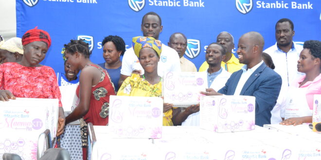 Alled Ronald Akugizibwe (right) handing over a mama kit to the expectant mothers. Photo: Yosam Gucwaki/The Albertine Journal