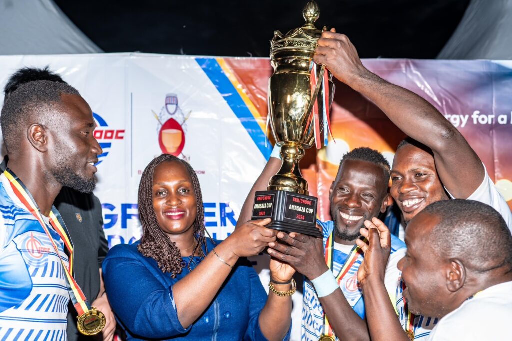 Aminah Bukenya, Head of Corporate Affairs department of CNOOC Uganda Limited shares a light moment with Buhanguzi County team who are the winners of the 2024 Tournament. Photo: Courtesy.