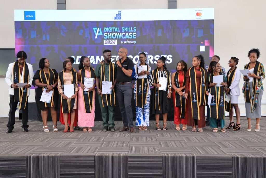 Michael Niyitegeka (holding microphone), the Executive Director at Refactory Academy, posing for a picture with some of the participants whp graduated in Tech skills. Credit: Courtesy.